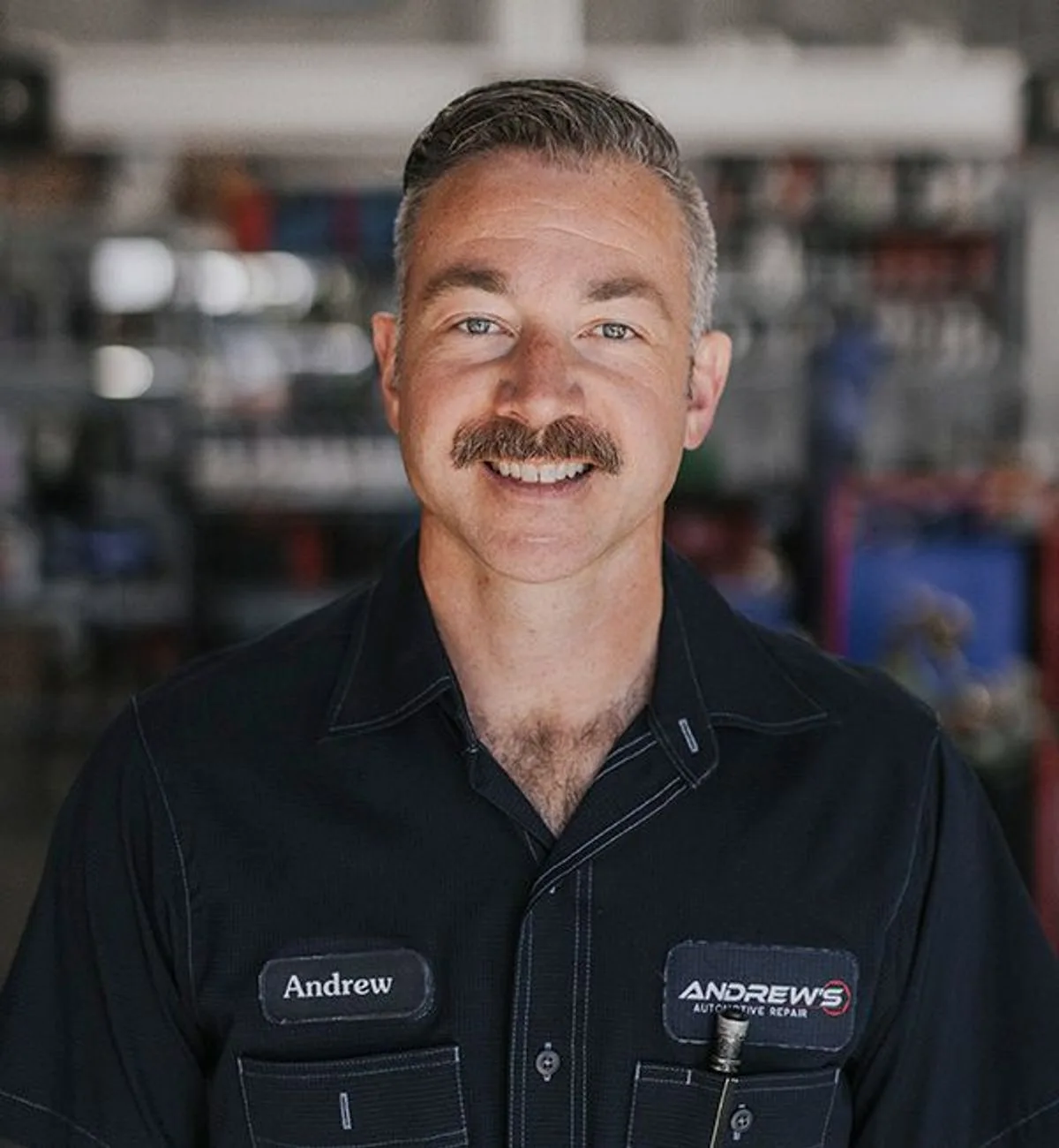 Andrew Elliot, owner of Andrew's Automotive Repair, smiling in the shop