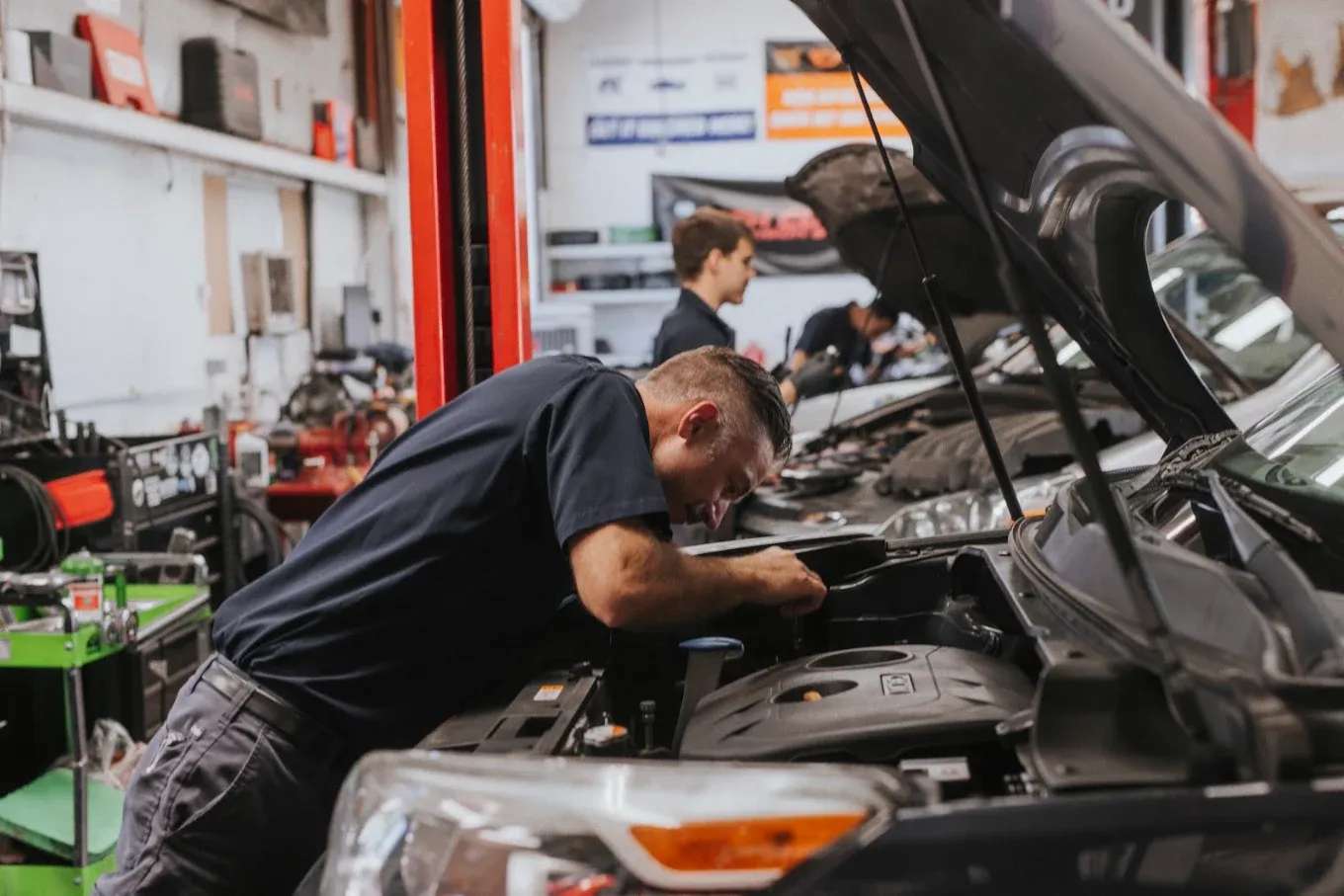 Andrew's technician working under the hood of a car in the Redding shop